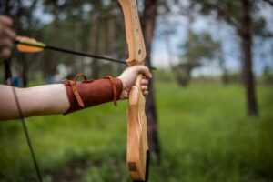 Doelwit voor boogschieten op een buitenterrein in Nieuwegein, met een recurve boog in beeld en kleurrijke schietschijven op de achtergrond, klaar voor gebruik tijdens een trainingssessie.